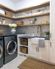 a washer and dryer in a small room with open shelving on the wall