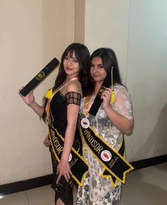 two beautiful women standing next to each other wearing sashes and holding onto their ribbons