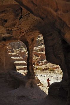 a person standing in the middle of a desert area with rocks and sand on both sides