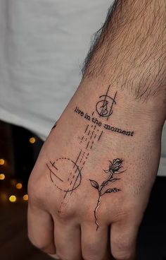 a man's hand with a tattoo on it that says love is the moment