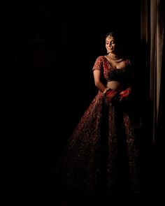 a woman in a red and black dress is posing for a photo with her hands on her hips