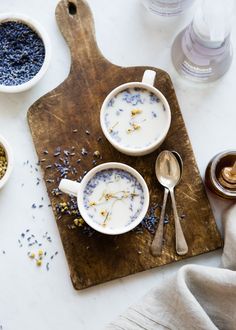 two cups of yogurt with lavender sprinkles on a cutting board