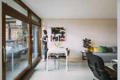 a woman is standing in the living room looking out onto the yard and pool area