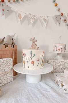 a cake sitting on top of a white plate next to boxes and bunting flags