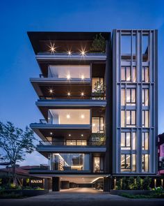 an apartment building with lots of windows and balconies on the top floor is lit up at night