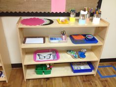 a wooden shelf filled with lots of crafting supplies on top of a hard wood floor