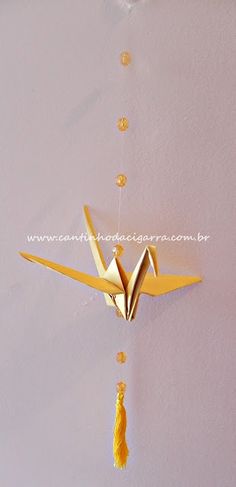 an origami bird hanging on the wall