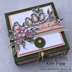 a close up of a card with flowers and birds on it, in front of a gray background