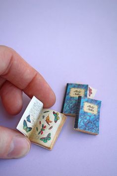 a miniature book is being held by a hand