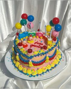 a birthday cake with candles and balloons on it