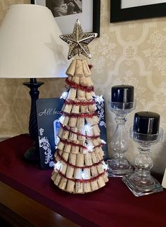 a christmas tree made out of wine corks on a table next to a lamp