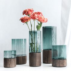 several vases with flowers in them sitting on a table next to each other,