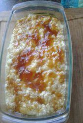 a casserole dish sitting on top of a wooden table covered in cheese and ketchup