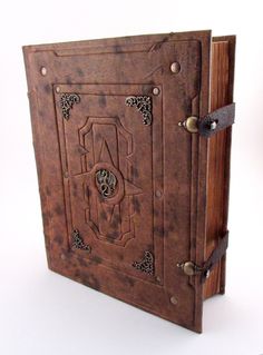 an old wooden box with metal handles and decorative designs on the front, hanging from a wall