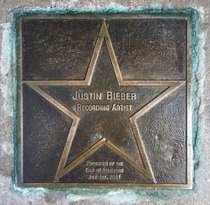 a star on the side of a building that says,'justin bleber recording artist '