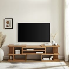 a flat screen tv mounted to the side of a wooden entertainment center in a living room