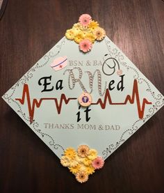 a decorated graduation cap with flowers on it and the words earn it thanks mom & dad