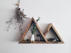 two wooden triangle shelves with plants on top