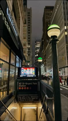 a city street at night with people walking down the sidewalk