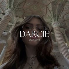 a woman with long hair wearing glasses and standing in front of an ornate building that says darcie