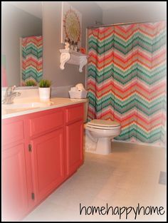 a bathroom with a shower curtain, toilet and sink in the background that has a colorful zigzag pattern on it