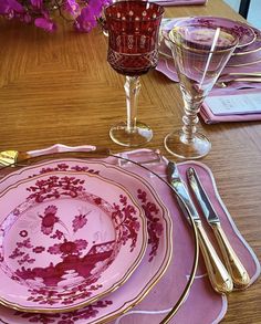 the table is set with pink and gold china