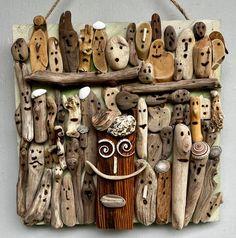 a wall hanging made out of wood with various faces and hands on it's sides