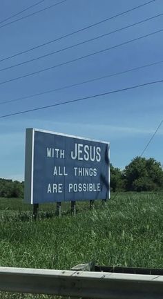 a blue sign that says with jesus all things are possible on it in the grass