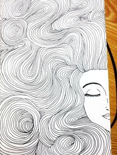 a drawing of a woman's face with wavy hair on top of a wooden table