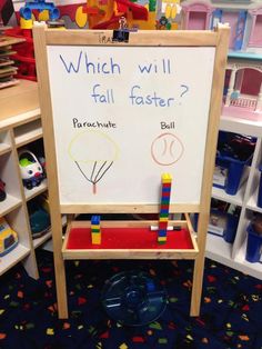 a child's play area with toys and a sign that says which will fall faster?