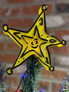 a yellow star ornament hanging from a christmas tree