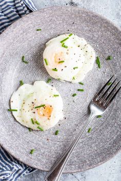 two fried eggs on a plate with a fork