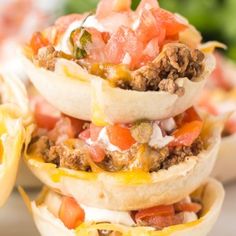 three tacos stacked on top of each other with cheese and toppings in them