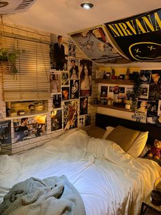 a bedroom with many pictures on the wall and a bed in front of it,