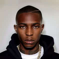 a young man with tattoos on his face wearing a hoodie and looking at the camera