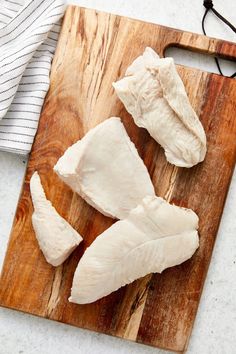 two pieces of chicken on a cutting board