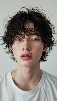 a young man with freckles on his face looks at the camera while wearing a white t - shirt