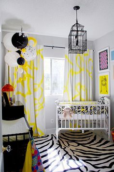 a baby's room with zebra print rug and yellow drapes on the window