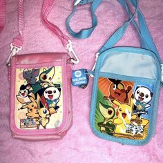 two purses with cartoon characters on them are laying on a pink blanket and one has a blue strap