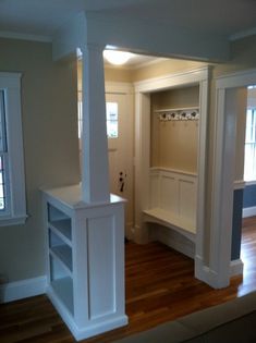 an empty living room with wood floors and white cabinets