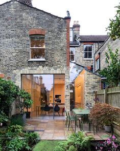 a brick house with an open patio and dining area