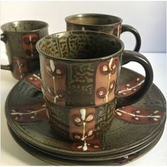 a set of four cups and saucers sitting on top of each other