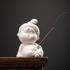 a small white statue sitting on top of a wooden table