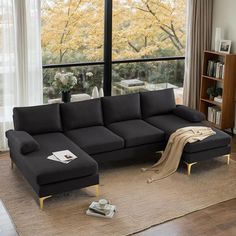 a living room with a large window and a black couch