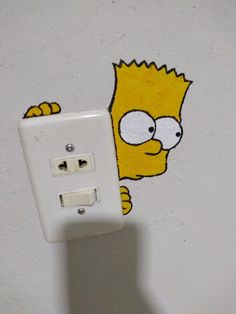 a light switch with the simpsons face painted on it's side, next to a wall sticker