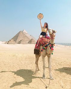 a woman riding on the back of a camel