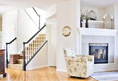 a living room filled with furniture and a fire place under a stair case next to a fireplace