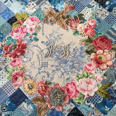 a blue and white patchwork quilt with flowers on it's center, in the middle