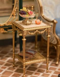 a miniature gold table with fruit on it