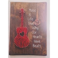 a string art piece with a red guitar on it that says music is life that's why our hearts have beats